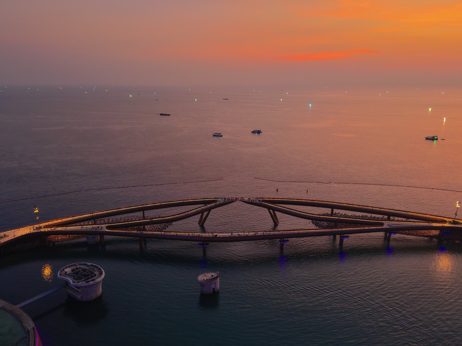 Aerial view of a waterfront structure at sunset